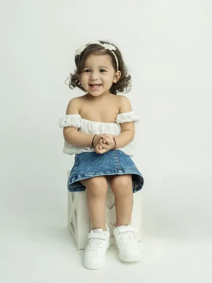 An adorable portrait of the little girl from the twin session, with a big, bright smile.