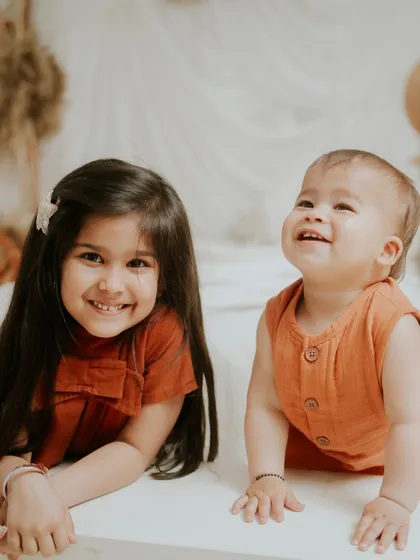 Two happy smiles. This sibling portrait is a perfect snapshot of their joyful connection.