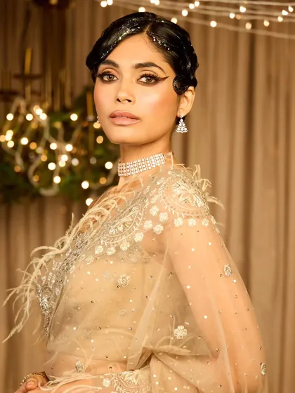 A collection showcasing a unique vintage cocktail look. The glitter-parted finger wave hairstyle and dramatic graphic eyeliner create a memorable and high-fashion statement.