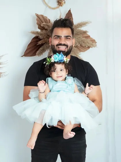 A proud father holds his son at his first birthday party. Event photography allows us to capture the celebration with all your friends and family.