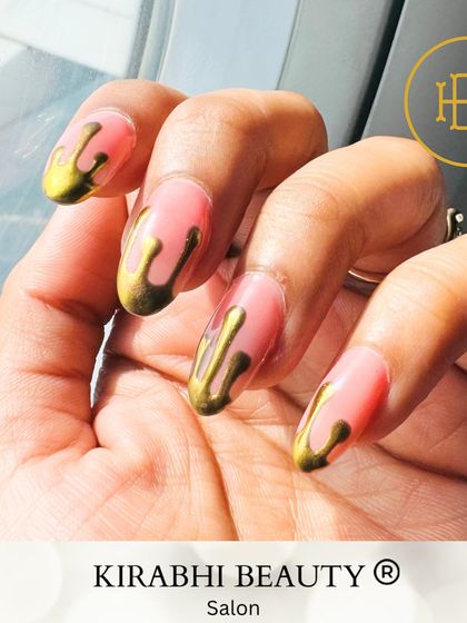 A full view of the gold drip nail art on a sheer pink base. This design is perfect for anyone wanting a bold and artistic manicure.