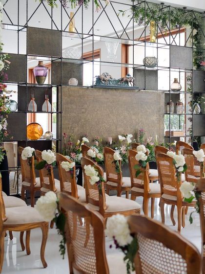 The indoor seating arrangement for the engagement, with a modern shelving backdrop filled with art pieces, perfectly balanced by floral columns.