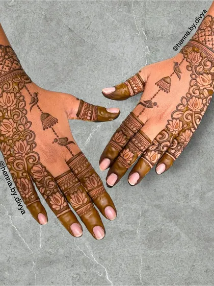 This design is a celebration of Indian artistry, featuring a mix of lotus flowers, birds, and hanging jhumkas. The pattern is intricate yet feels light and elegant.