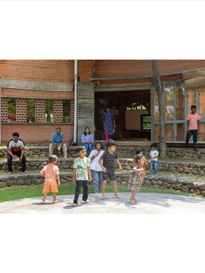 Architecture can bring people together. This stepped, semi-circular seating area at the Foothill Learning Centre serves as an informal gathering spot, encouraging interaction between children and adults in a relaxed, open-air setting.