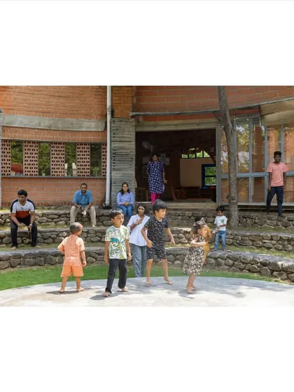 Architecture can bring people together. This stepped, semi-circular seating area at the Foothill Learning Centre serves as an informal gathering spot, encouraging interaction between children and adults in a relaxed, open-air setting.
