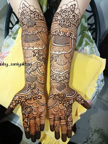 This image pairs the intricate foot design with the bride's hand mehendi, showing a complete and cohesive bridal look.