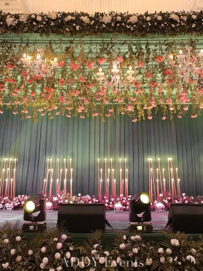 A clear, eye-level view of the teal and floral stage. This shot provides a good look at the hanging floral installation and the arrangement of lights, demonstrating the rich textures and colors we use in our designs.