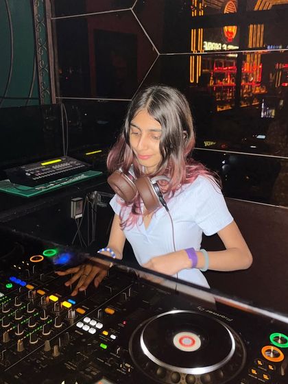 In the zone at Sincity, with my headphones on, focused on the mix. The geometric, reflective walls of the club create a cool, modern backdrop.