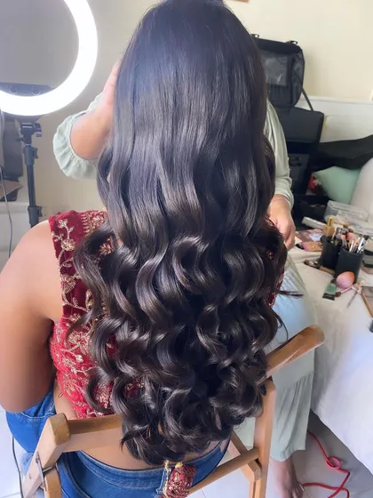 A shot of the finished reception curls, showing their volume and shine. This is a timeless and elegant hairstyle that suits any modern bridal outfit.