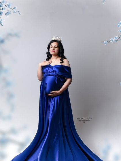 A regal pose for a queen. Wearing a delicate crown, this mom-to-be looks absolutely majestic in her royal blue gown.