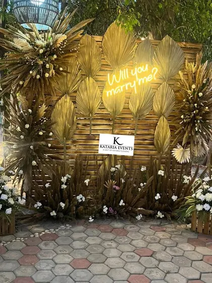 I also design proposals with a more natural, boho aesthetic. This setup features a backdrop made of bamboo and dried grasses, decorated with golden palm leaves and a warm neon sign. It’s perfect for a romantic, down-to-earth moment.