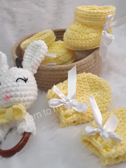 The complete yellow baby gift set, including the bunny rattle with a wooden teether, booties, and mittens.