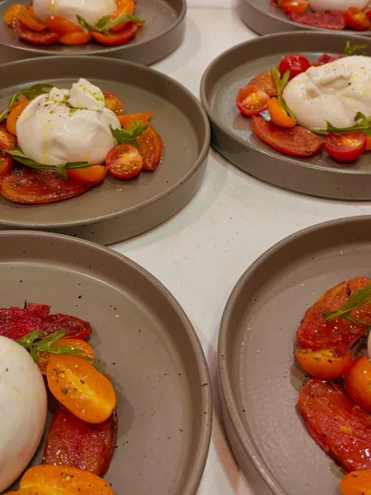 Fresh Tomato Burrata Carpaccio, plated and ready to be served. This dish from our Italian menu is a simple yet divine combination of creamy burrata and sweet tomatoes.