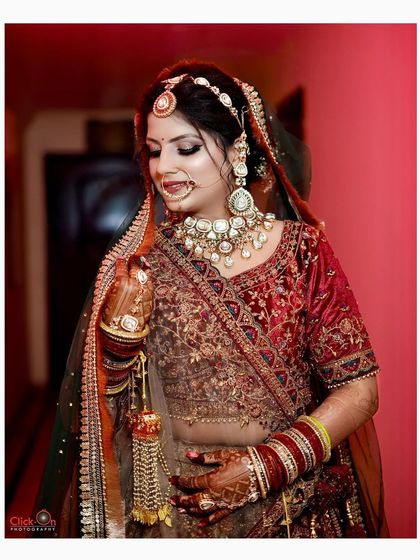 A classic three-quarter bridal portrait, focusing on the rich details of the velvet lehenga and heavy jewelry.
