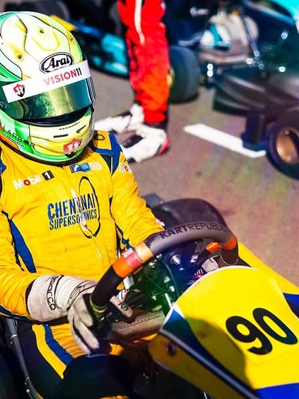 A driver in his colorful helmet and race suit, ready for the night race.