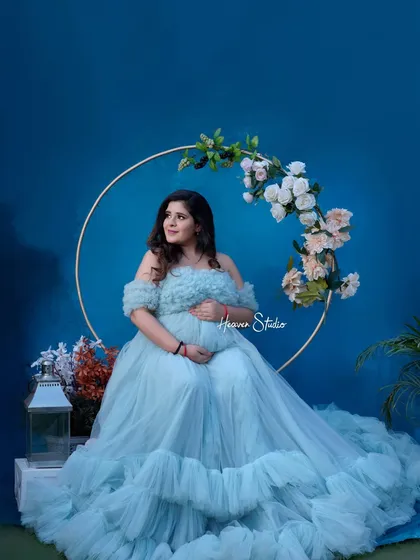 A full view of the magnificent blue tulle gown. This portrait showcases the beautiful details and volume of the dress, making the mother-to-be look like she's floating on a cloud.