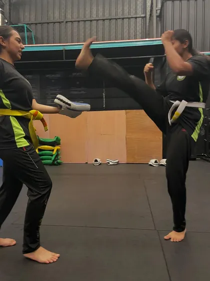 Another great shot of a student practicing her high kick, showing excellent form and flexibility.