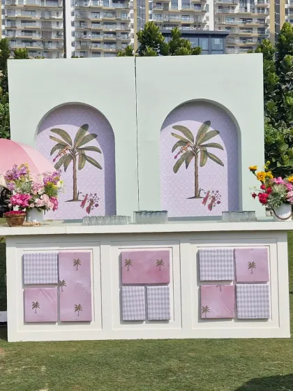 The custom-built bar for our pastel-themed event. The front panels were designed with a checkerboard and palm tree motif, while the arched back featured elegant palm illustrations, tying perfectly into the "prints, palms, and petals" concept.