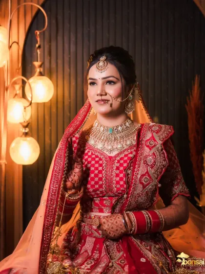 A stunning bridal portrait with beautiful ambient lighting, highlighting her features and elegant red lehenga.