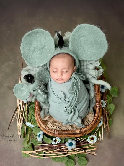 The cutest little mouse in the house. This whimsical setup features a newborn in a sweet mouse costume, nestled in a basket with matching props.