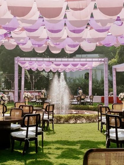 The full expanse of the Mehendi venue, showing the multiple canopied sections for seating, dining, and lounging, all unified by a soft pastel color scheme.