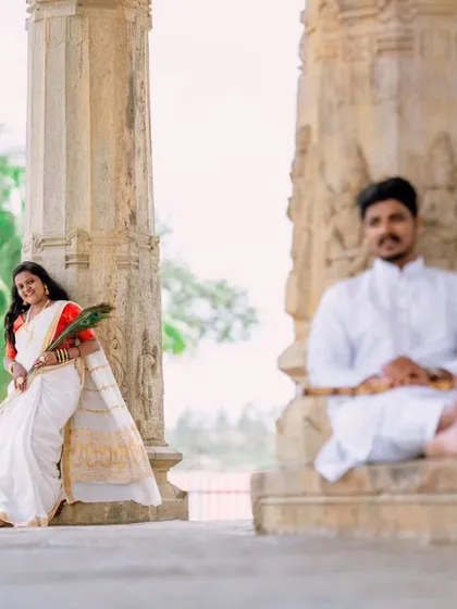 An artistic shot with the woman in sharp focus, smiling while her partner sits meditatively in the background. This selective focus technique adds a storytelling element to the portrait.