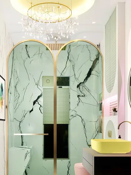 A variation of the pastel kids' bathroom concept, this time with arched shower doors that mimic the other shapes in the room. The design is cohesive and full of personality.
