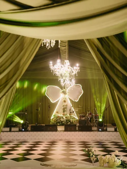 Inspired by a love for modern romance, we designed "The Big Bow Affair." This stage, with its grand illuminated bow and cascading florals under crystal chandeliers, set the scene for a magical evening of celebration. It’s about taking a simple idea and turning it into a breathtaking reality.