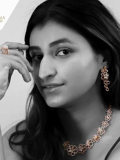 A black and white version of the model wearing the floral diamond set, emphasizing the form and sparkle of the pieces.