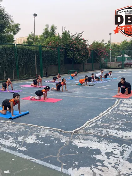 Here, the team practices the cat-cow pose on their mats. This exercise is excellent for improving spine flexibility and core stability, helping to prevent back injuries during intense physical activity.