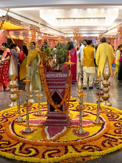 A beautiful Janmashtami celebration setup, complete with a central tulsi plant, intricate rangoli made of flowers, and traditional diyas. We curate every detail to reflect the spirit of the festival.