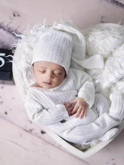 A newborn nestled in a heart-shaped bowl, with a calendar block showing a special date. This is a wonderful way to announce a birth or commemorate the day of the shoot.