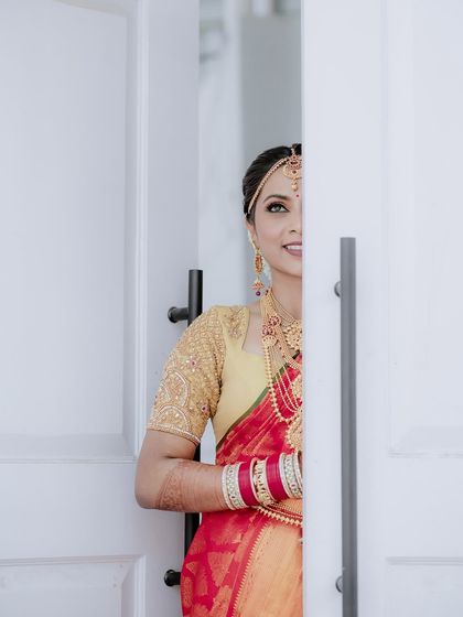 A creative shot of the bride peeking from behind a door, with only half of her face visible. It creates a sense of mystery and anticipation.