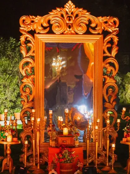 This photo corner is designed for pure elegance. A grand, ornate gold mirror reflects the warm glow of dozens of candles, creating a romantic and dramatic spot for guests to capture beautiful moments.