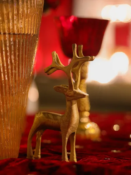 A small golden deer figurine placed on a red velvet tablecloth. I use such details to add a touch of whimsy and symbolism to my royal-themed decor.