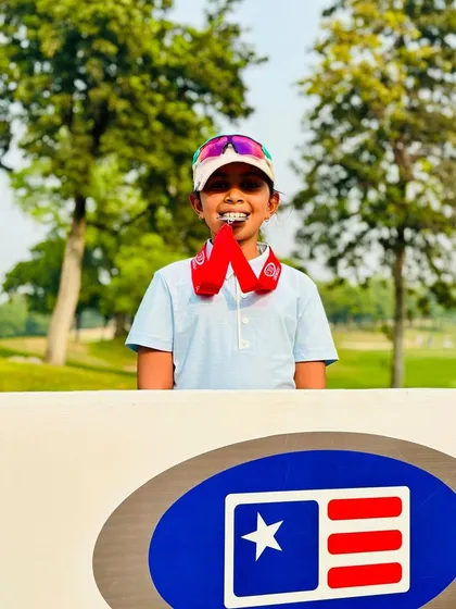 Aahana Shrivastava proudly bites her medal, celebrating a successful run in the US Kids tour.