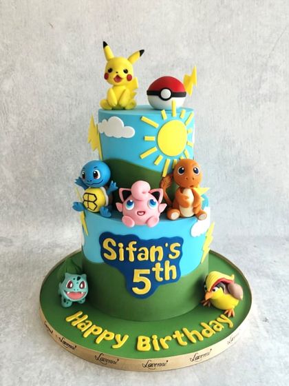 A Pokémon party for Sifan's 5th birthday! This two-tiered cake is covered in all his favourite characters, including Pikachu, Squirtle, Charmander, and Bulbasaur.