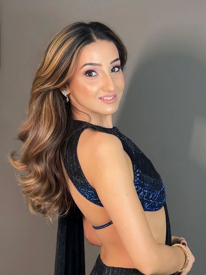 A glamorous open hairstyle with highlights for a Diwali party. The soft waves and side part create a chic and festive look.