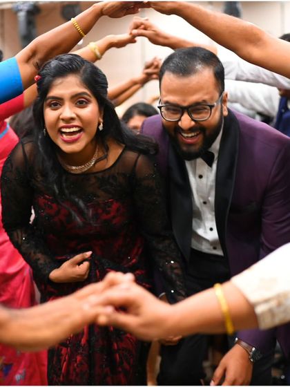 Surrounded by friends and family, Cristina and Kevin make their way through a joyful human tunnel, their faces lit up with laughter. These are the candid moments that truly define a celebration.