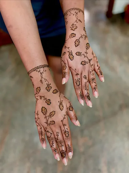 For a modern and elegant touch, this delicate floral vine design is a wonderful choice. It was a pleasure to create this for a repeat client for her reception, showing how versatile henna art can be for different wedding events.