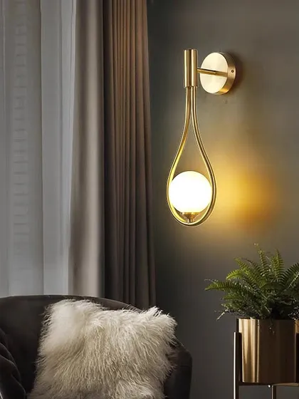 I designed this wall light to feel like a drop of light. The single opal sphere is cradled in a teardrop-shaped golden frame, creating a soft, celestial glow. It's a simple yet elegant addition to a cozy corner or hallway.