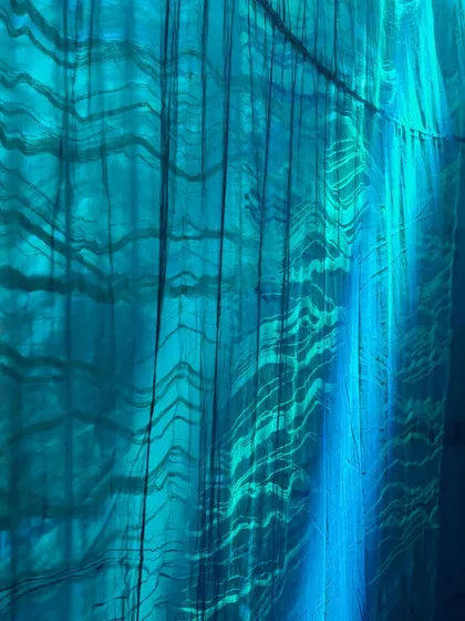 Another detail from 'Into The Deep', where the interplay of light and custom-woven fabric creates patterns reminiscent of ripples on water. The experience is designed to be both sonic and visual.