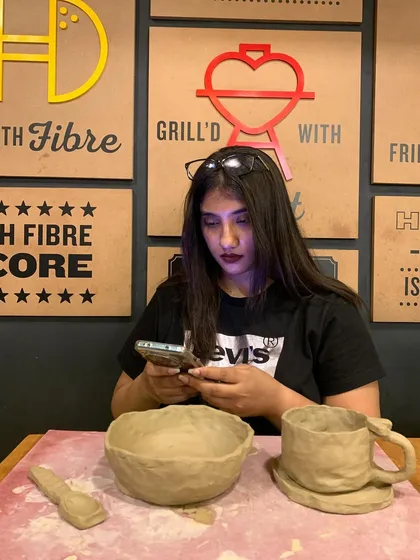 A participant with her freshly made bowl, mug, and spoon after a session in Chennai. It's so rewarding to see people leave with a set of items they crafted themselves.