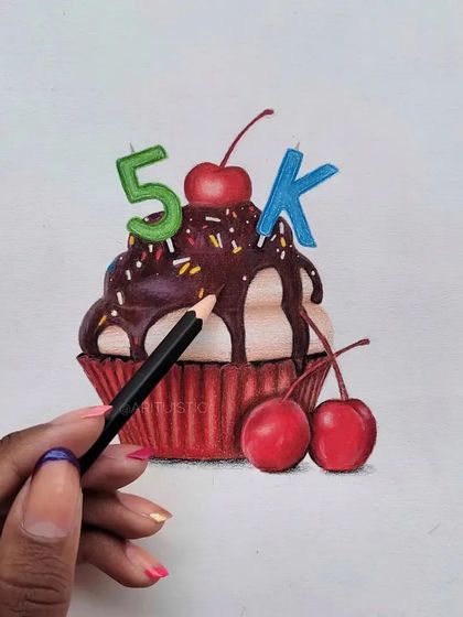 Me holding a pencil to the finished cupcake drawing, giving a sense of scale.