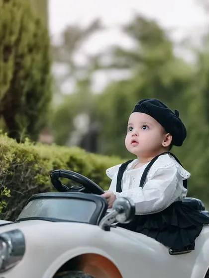 A curious glance from the driver's seat. This toddler looks so sweet and thoughtful while posing in her little white car during our outdoor session.