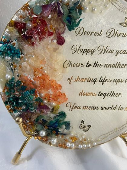 A close-up of the personalized New Year's frame, showing the intricate details of the preserved flowers and pearls.