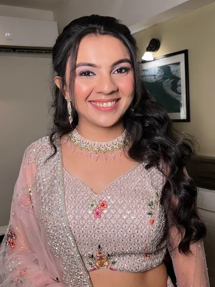 This bride's smile is infectious. Her makeup is fresh and youthful, with a focus on luminous skin and soft, shimmery eyeshadow.
