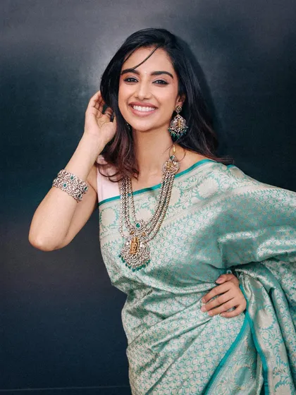 A full look from the teal silk saree series, showing the beautiful drape of the fabric. The addition of a silver bracelet completes the traditional yet understated look.