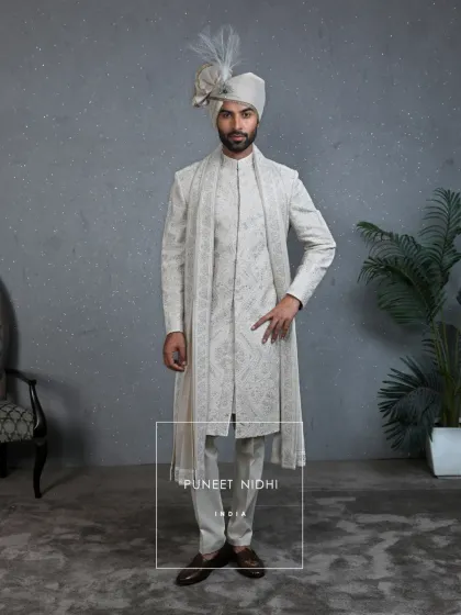 This ivory handloom silk sherwani combines classic patterns with contemporary tailoring. Every stitch tells a story of artistry and precision, making it an ideal choice for grooms who want to blend heritage with a modern touch.
