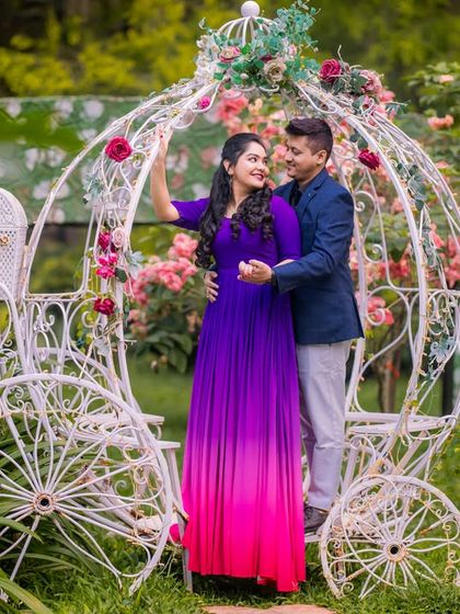 A romantic couple poses by the Cinderella carriage, a perfect fairytale setting.